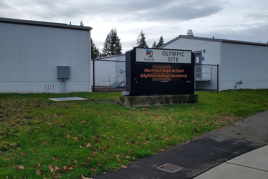 A sign in front of buildings that reads "Maritime High School"